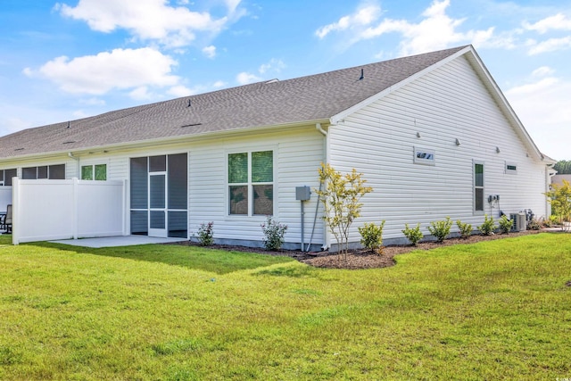 rear view of property with a patio, a yard, and central AC unit