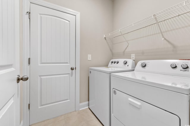 washroom featuring washer and clothes dryer and light tile patterned floors