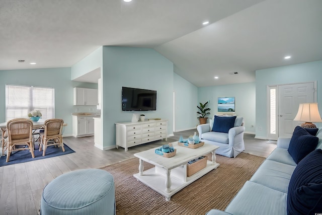 living room featuring light hardwood / wood-style floors and lofted ceiling