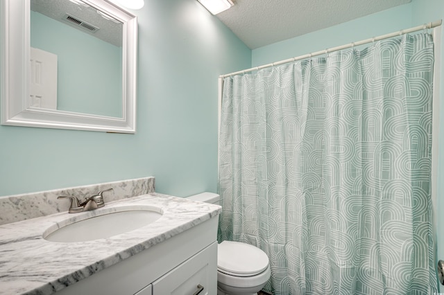 bathroom featuring vanity, a textured ceiling, and toilet