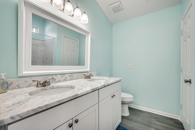 bathroom with hardwood / wood-style flooring, vanity, and toilet