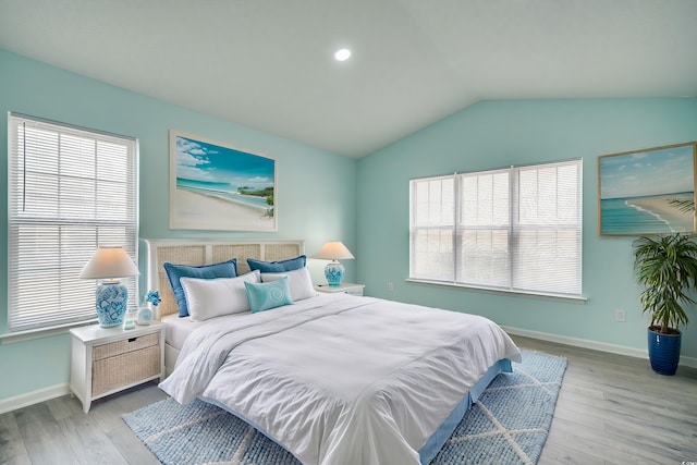 bedroom with light hardwood / wood-style floors and lofted ceiling