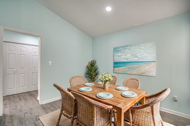 dining space featuring hardwood / wood-style floors and lofted ceiling