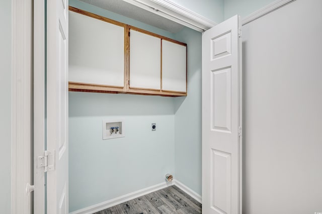 clothes washing area with electric dryer hookup, hookup for a washing machine, cabinets, and light hardwood / wood-style floors