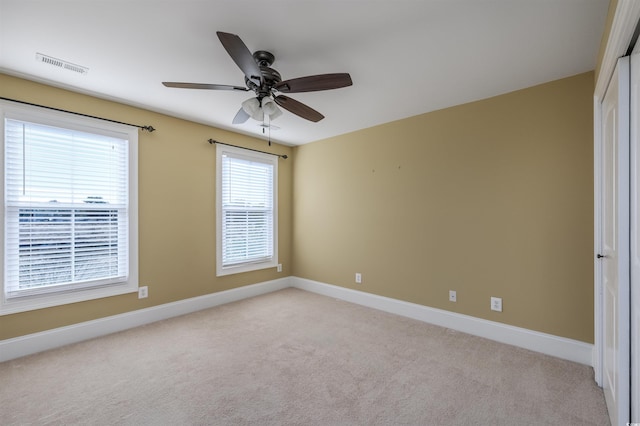 empty room with ceiling fan and light colored carpet