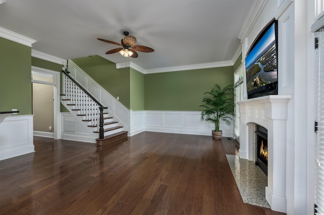 unfurnished living room with a high end fireplace, dark wood-type flooring, ceiling fan, and ornamental molding