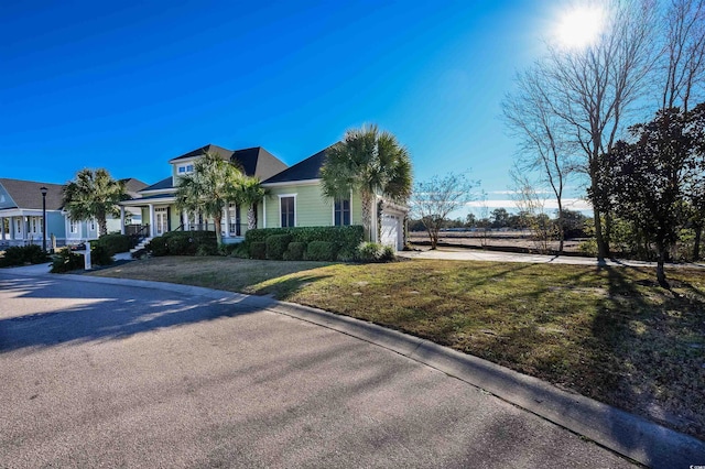 view of front of house with a front lawn, a porch, and a garage