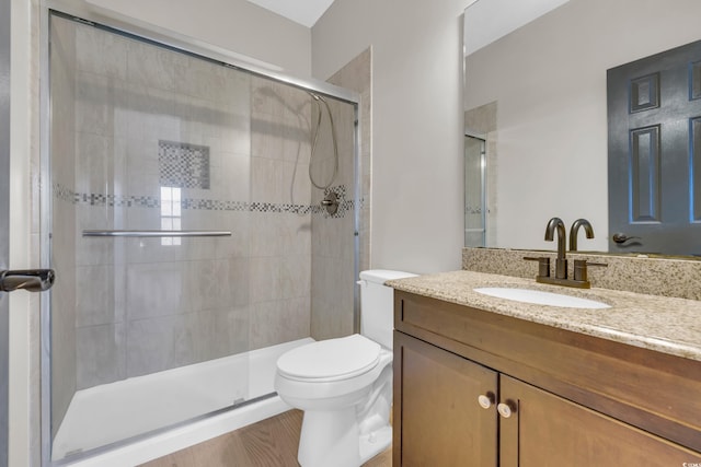 full bath featuring toilet, a shower stall, and vanity