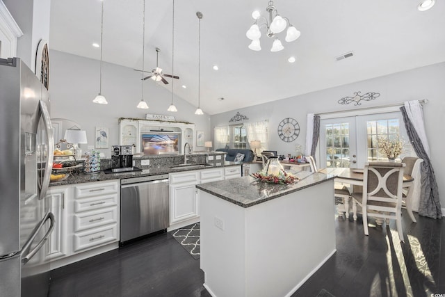 kitchen featuring pendant lighting, french doors, white cabinets, dark stone countertops, and stainless steel appliances