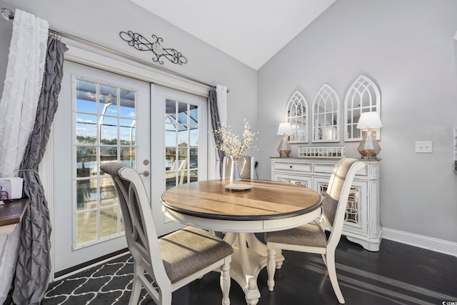 dining area with dark hardwood / wood-style flooring, french doors, and vaulted ceiling