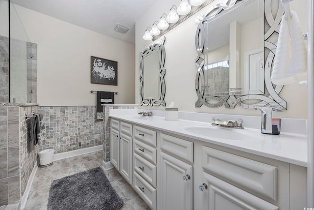 bathroom with vanity and tile walls