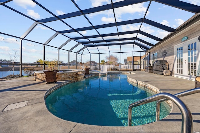 view of pool with a patio area, a lanai, an in ground hot tub, and french doors