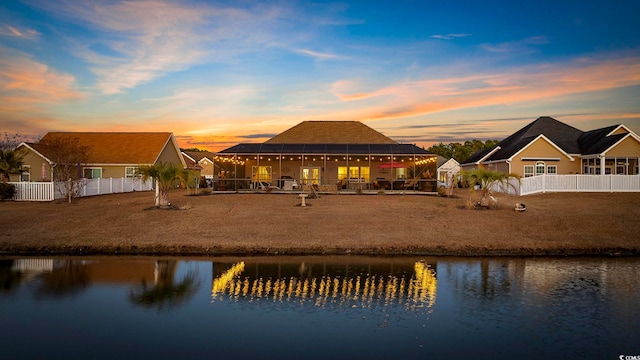 back house at dusk with a water view