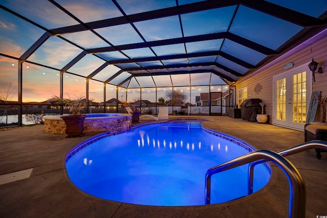 pool at dusk with glass enclosure, french doors, an in ground hot tub, a grill, and a patio