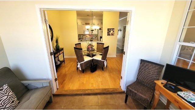 dining space with dark tile patterned floors and a notable chandelier