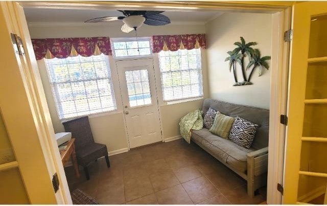 sitting room with ceiling fan and dark tile patterned floors