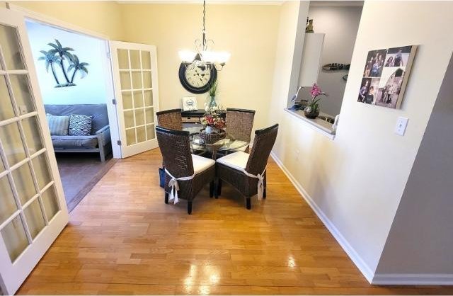 dining room featuring hardwood / wood-style floors, a notable chandelier, and french doors