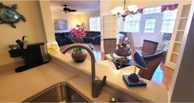 dining space with wood-type flooring and ceiling fan with notable chandelier