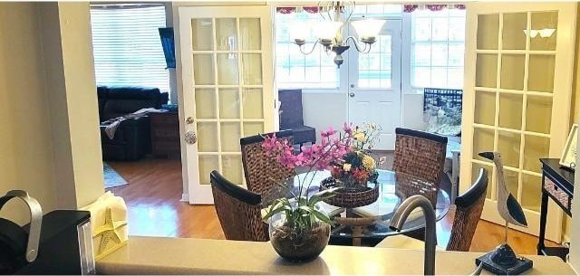 dining area featuring an inviting chandelier, wood-type flooring, and french doors