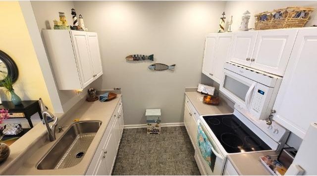 kitchen with white cabinetry and white appliances