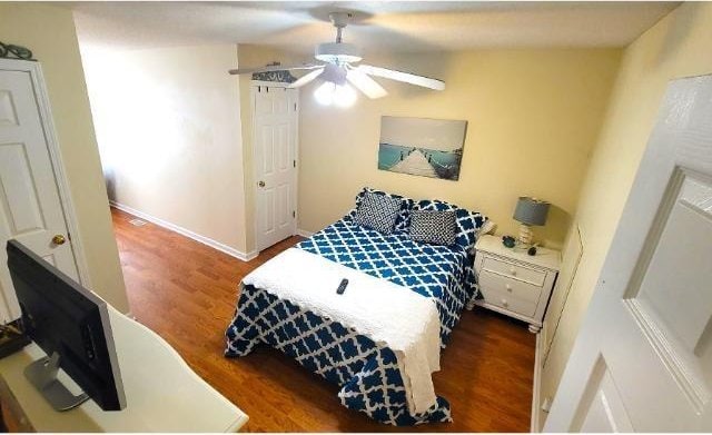 bedroom with dark hardwood / wood-style flooring and ceiling fan