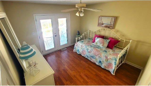 bedroom featuring ceiling fan, dark hardwood / wood-style floors, access to outside, and french doors