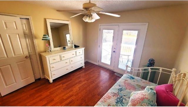 bedroom with access to exterior, ceiling fan, french doors, dark wood-type flooring, and a textured ceiling