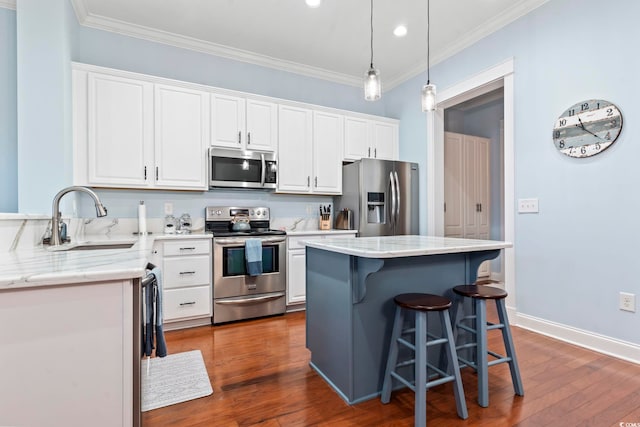 kitchen with a center island, dark wood-type flooring, white cabinets, sink, and stainless steel appliances