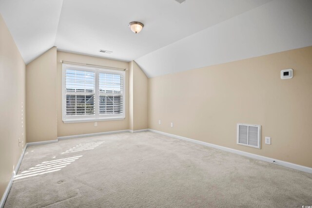 additional living space featuring carpet, visible vents, baseboards, and lofted ceiling