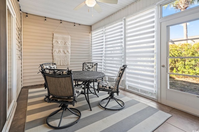 sunroom with outdoor dining area and a ceiling fan