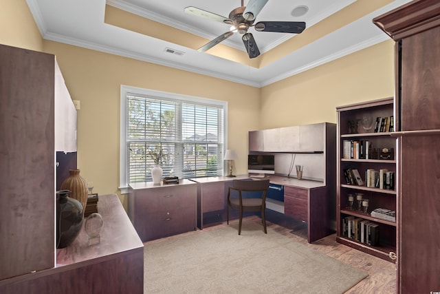 office featuring a raised ceiling, crown molding, light hardwood / wood-style flooring, and ceiling fan