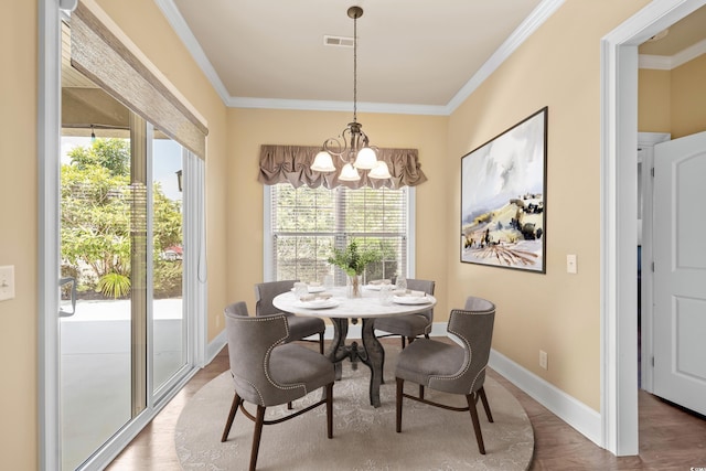 dining area with a notable chandelier, wood-type flooring, and crown molding