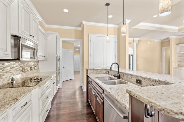 kitchen with white cabinetry, sink, decorative light fixtures, and appliances with stainless steel finishes