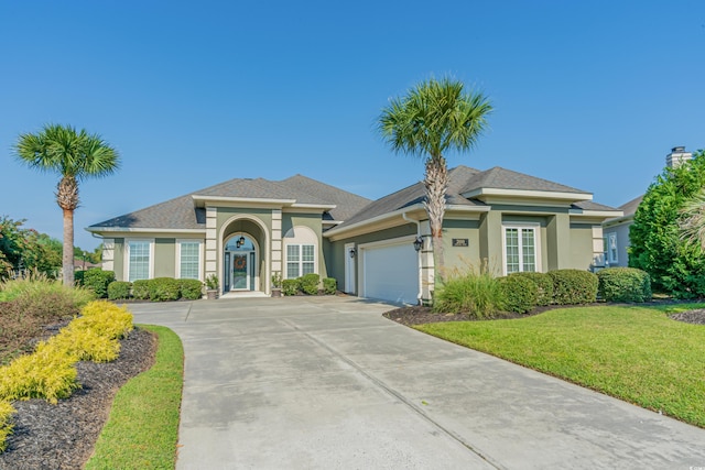 view of front of property featuring a garage and a front lawn