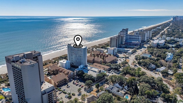 birds eye view of property with a water view and a beach view