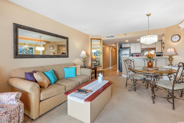 carpeted living room with a chandelier