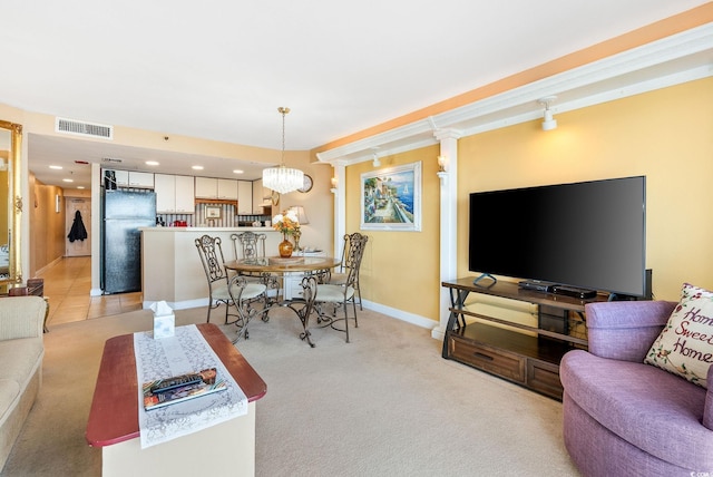 living room with light colored carpet, decorative columns, and an inviting chandelier