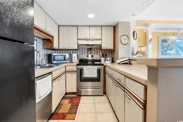 kitchen with light tile patterned flooring, sink, and stainless steel appliances