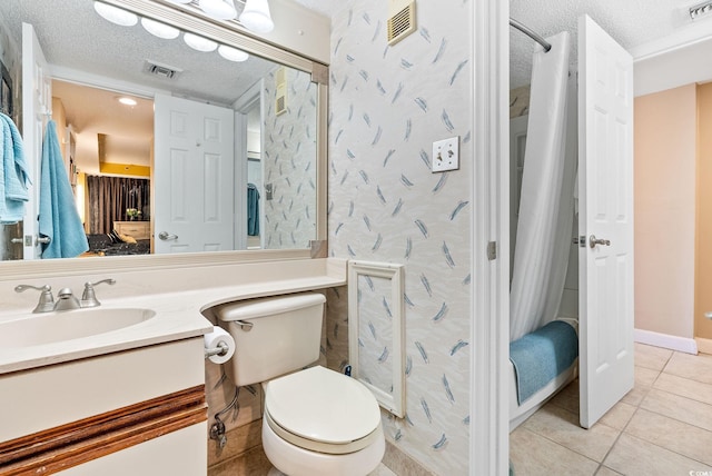 bathroom featuring tile patterned floors, vanity, toilet, and a textured ceiling