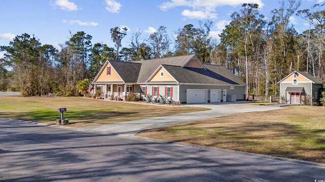 view of front of house featuring a garage, covered porch, and a front lawn