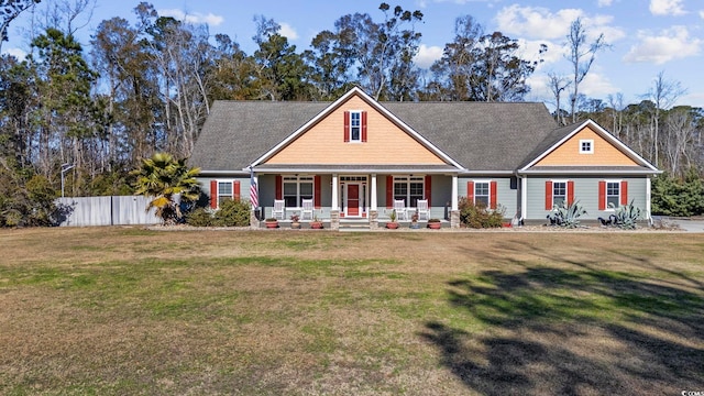 craftsman-style home with covered porch, fence, and a front yard