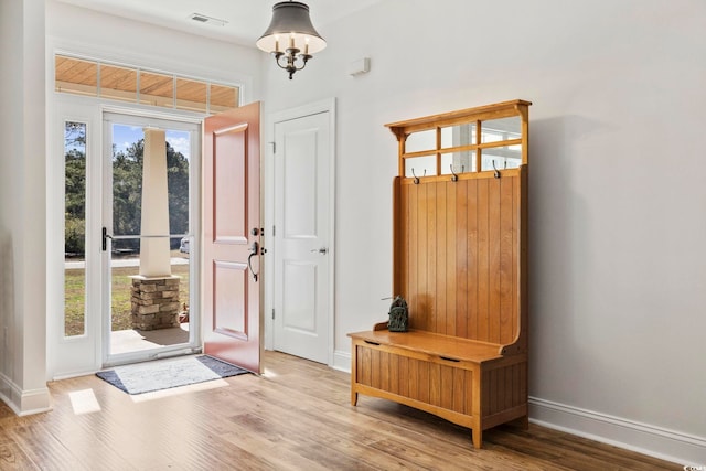 entryway with wood finished floors, visible vents, and baseboards