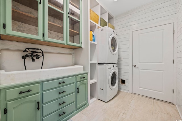 laundry area featuring stacked washer / dryer and wooden walls