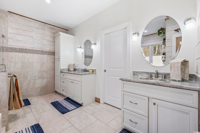 full bathroom featuring tile patterned flooring, two vanities, and a sink