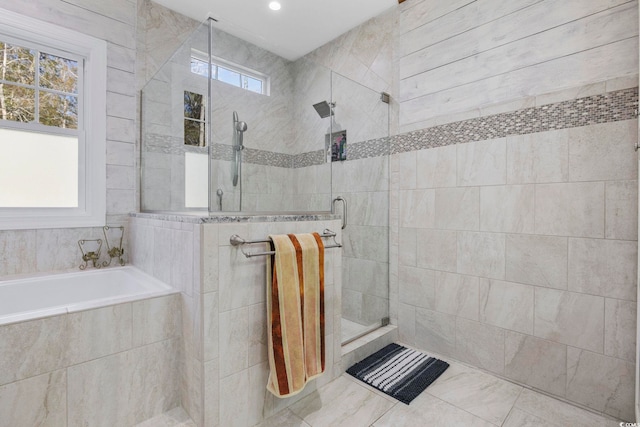 bathroom featuring plenty of natural light, a shower stall, and a bath