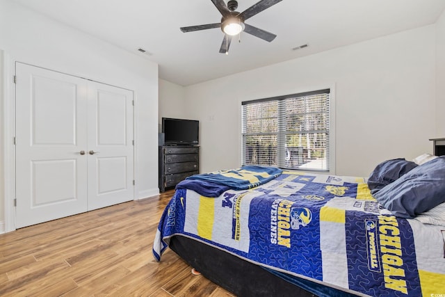 bedroom with a ceiling fan, a closet, visible vents, and wood finished floors