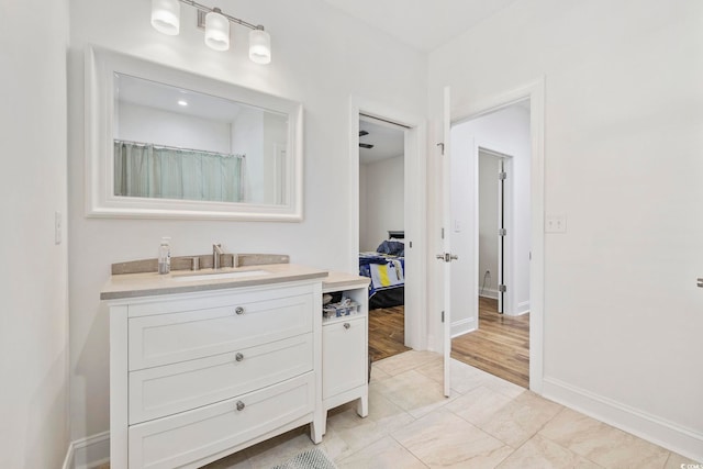 full bathroom featuring vanity and baseboards