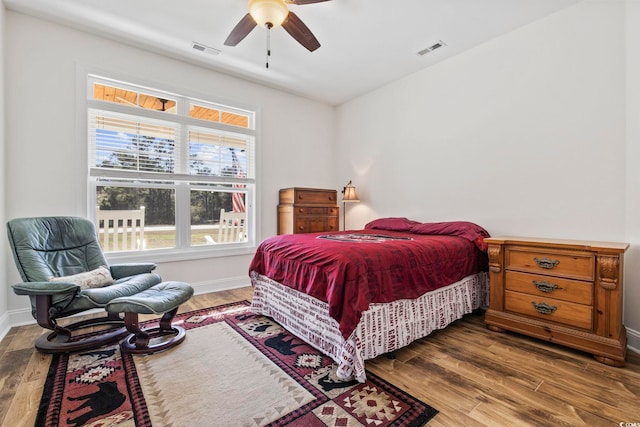 bedroom featuring baseboards, visible vents, and wood finished floors