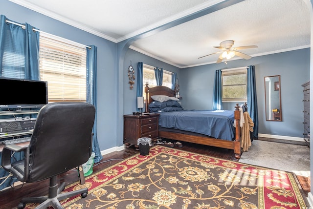 carpeted bedroom with a textured ceiling, ceiling fan, and crown molding