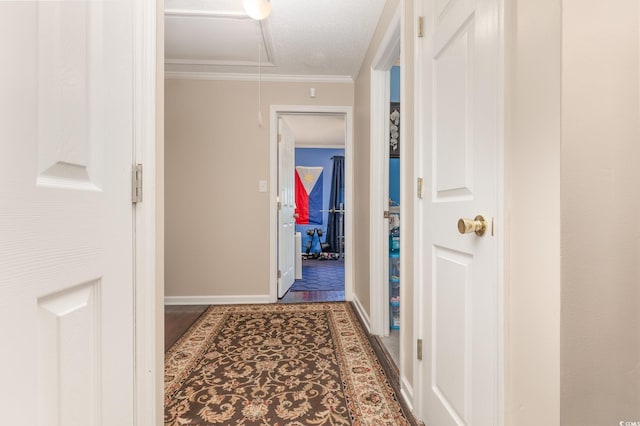 corridor with a textured ceiling and crown molding